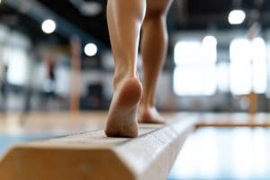 a gymnast carefully balancing on a beam
